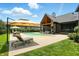 Backyard features a pool, lounge chairs, covered outdoor living area, and green lawn at 7116 Trail Ridge Ln, Indianapolis, IN 46259