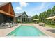 Backyard features a pool, green lawn, covered outdoor living, and outdoor dining at 7116 Trail Ridge Ln, Indianapolis, IN 46259