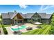 Expansive backyard featuring a pool, outdoor seating, dining area, and fireplace for luxurious outdoor living at 7116 Trail Ridge Ln, Indianapolis, IN 46259