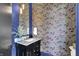 Stylish powder room featuring unique wallpaper, modern vanity, and elegant fixtures at 7116 Trail Ridge Ln, Indianapolis, IN 46259