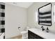 This modern bathroom features striped tile, a vanity with a marble top, and stylish fixtures at 7116 Trail Ridge Ln, Indianapolis, IN 46259