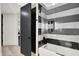 The modern bathroom features a striped tile shower, glass door, and sleek design at 7116 Trail Ridge Ln, Indianapolis, IN 46259