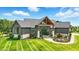 A luxurious home featuring a stone and wood facade and a beautifully maintained lawn at 7116 Trail Ridge Ln, Indianapolis, IN 46259