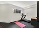 Home gym featuring a treadmill, yoga mat, window and durable rubber flooring at 7116 Trail Ridge Ln, Indianapolis, IN 46259