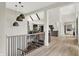 Bright hallway with wooden floors, decorative lighting and staircase with metal spindles at 7116 Trail Ridge Ln, Indianapolis, IN 46259