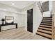 Hallway featuring wood-look floors, modern lighting, and staircase with wood railing at 7116 Trail Ridge Ln, Indianapolis, IN 46259