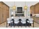 Stylish kitchen with a black island, marble counters, and modern pendant lighting at 7116 Trail Ridge Ln, Indianapolis, IN 46259