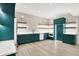 Stylish kitchenette boasts elegant emerald-green cabinets, sleek countertops, and modern stainless-steel appliances at 7116 Trail Ridge Ln, Indianapolis, IN 46259