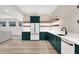 This stylish kitchenette includes elegant emerald-green cabinets, and stainless steel appliances at 7116 Trail Ridge Ln, Indianapolis, IN 46259