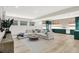 Spacious living room with a comfortable sectional sofa, stylish rug, and modern kitchenette with striking green cabinets at 7116 Trail Ridge Ln, Indianapolis, IN 46259