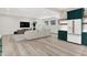 Living room with a sectional sofa, modern kitchenette with striking green cabinets at 7116 Trail Ridge Ln, Indianapolis, IN 46259
