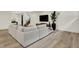 Bright and airy living room with a large sectional sofa, TV, staircase, and wood-look floors at 7116 Trail Ridge Ln, Indianapolis, IN 46259