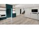Open living space includes kitchenette with emerald cabinets, modern stairs, and sectional sofa at 7116 Trail Ridge Ln, Indianapolis, IN 46259