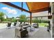 Charming outdoor living space with a stone fireplace, comfortable seating, and access to the pool area at 7116 Trail Ridge Ln, Indianapolis, IN 46259