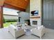 Covered outdoor living space features a stone fireplace, TV, and comfortable seating at 7116 Trail Ridge Ln, Indianapolis, IN 46259