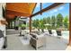 Relaxing outdoor area with a stone fireplace, comfortable seating, and a view of the pool and backyard at 7116 Trail Ridge Ln, Indianapolis, IN 46259