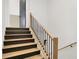 Staircase with wooden railings and risers and a view of an open doorway at 7116 Trail Ridge Ln, Indianapolis, IN 46259