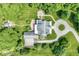 Overhead shot showcasing home's layout, landscaped grounds, circular driveway, and natural surroundings at 7182 Hunt Club Dr, Zionsville, IN 46077