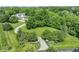 Stunning aerial view of a home on a sprawling lot with mature trees, a winding driveway, and lush landscaping at 7182 Hunt Club Dr, Zionsville, IN 46077