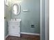 Powder room featuring white vanity and sink, complemented by light blue walls and brick floor at 7182 Hunt Club Dr, Zionsville, IN 46077