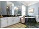 Luxurious bathroom featuring a marble countertop, soaking tub, and elegant fixtures at 7182 Hunt Club Dr, Zionsville, IN 46077
