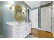 Bathroom featuring white vanity, gold-framed mirror and hardwood floors at 7182 Hunt Club Dr, Zionsville, IN 46077