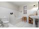 Well-lit bathroom featuring classic white tiles, pedestal sink and built-in shelving at 7182 Hunt Club Dr, Zionsville, IN 46077