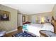 Comfortable bedroom with patterned wallpaper, hardwood floors, and cozy quilt at 7182 Hunt Club Dr, Zionsville, IN 46077