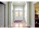 Elegant entryway featuring arched doorways, a decorative glass door, marble floors, and classic details at 7182 Hunt Club Dr, Zionsville, IN 46077