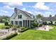 Attractive two-story home featuring a screened-in porch, brick patio, and manicured gardens at 7182 Hunt Club Dr, Zionsville, IN 46077