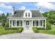 Charming home showcasing a symmetrical facade, pillared porch, and manicured landscaping at 7182 Hunt Club Dr, Zionsville, IN 46077
