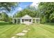 Charming outbuilding with white pergola, green and white awning, surrounded by lush green grass and trees at 7182 Hunt Club Dr, Zionsville, IN 46077