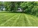 Expansive green lawn dotted with mature trees frames this elegant home with classic architecture at 7182 Hunt Club Dr, Zionsville, IN 46077