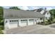 Three-car garage with white doors and painted brick facade, with a partial view of the house at 7182 Hunt Club Dr, Zionsville, IN 46077