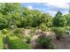 Lush garden featuring blooming rose bushes, trimmed hedges, and gravel pathways with natural seating at 7182 Hunt Club Dr, Zionsville, IN 46077