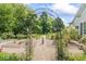 Serene garden featuring an iron archway, gravel pathway, and meticulously maintained rose bushes at 7182 Hunt Club Dr, Zionsville, IN 46077