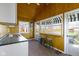 Sunroom kitchenette with white cabinets, neutral countertops, and awning-covered windows looking out on the lawn at 7182 Hunt Club Dr, Zionsville, IN 46077