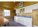 Interior shot of kitchenette with white cabinets, blue countertops, and wood paneled walls at 7182 Hunt Club Dr, Zionsville, IN 46077