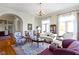 Bright living room features a decorative rug, elegant furnishings, and archway leading to a grand foyer at 7182 Hunt Club Dr, Zionsville, IN 46077