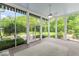 Enclosed sunroom with large windows, tile floor, and view of the lush backyard at 7182 Hunt Club Dr, Zionsville, IN 46077
