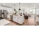 Open kitchen with stainless steel appliances, island with sink, and view into the living room at 7258 Selah Ln, Noblesville, IN 46062