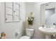 Cozy powder room features a pedestal sink, decorative wall accents, and neutral paint at 7258 Selah Ln, Noblesville, IN 46062