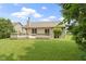 A spacious backyard showcasing a large wooden deck, lush lawn, mature trees, and manicured landscaping at 7335 Pymbroke Dr, Fishers, IN 46038