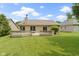 A spacious backyard showcasing a large wooden deck, lush lawn, mature trees, and manicured landscaping at 7335 Pymbroke Dr, Fishers, IN 46038