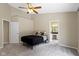 Neutral bedroom with ceiling fan, door to en-suite bathroom, and a comfortable bed at 7335 Pymbroke Dr, Fishers, IN 46038