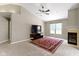 Spacious living room featuring a fireplace, a ceiling fan, and large windows at 7335 Pymbroke Dr, Fishers, IN 46038