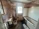 Aged bathroom featuring a floral wallpaper, a window, toilet and a bathtub at 811 W 25Th St, Indianapolis, IN 46208