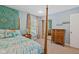 Bedroom with a four-poster bed, neutral carpet, and a mirrored closet for ample storage at 8330 Claridge Rd, Indianapolis, IN 46260