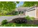 Inviting home exterior with beautiful landscaping, a gray facade, and mature trees providing shade at 8330 Claridge Rd, Indianapolis, IN 46260