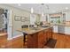 Bright kitchen with stainless steel appliances, island with seating and granite countertops, and hardwood flooring at 8330 Claridge Rd, Indianapolis, IN 46260